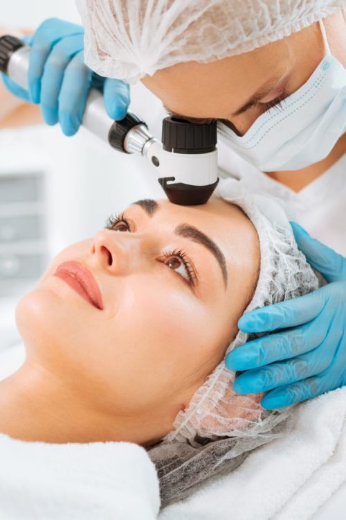 Professional dermatology. Pleasant young woman having her skin checked while visiting a dermatology clinic
